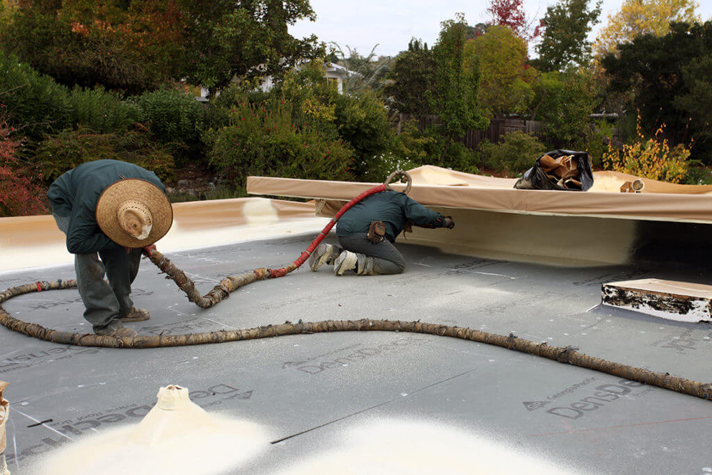 Armstrong Foam Roofing - two men on a flat roof installing foam roofing